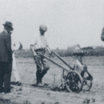 This is a photo of Frank Held demonstrating the GroMor Cultivator on his farm. 
